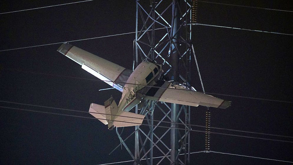 dpatopbilder - Bange Stunden für zwei Männer, die mit einem Kleinflugzeug in 30 Metern Höhe in einem Strommast festhängen. Foto: Tom Brenner/AP/dpa