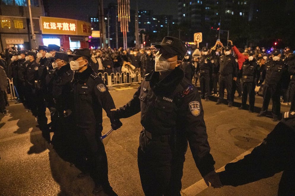 Chinesische Polizisten versuchen, einen Protestmarsch am 27. November in Peking zu stoppen.