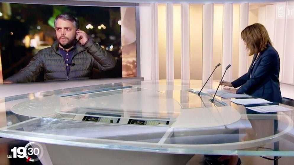 Berichterstatten mit Seitenblick: RTS-Korrespondent Michael Peuker wehrt während der Liveschaltung chinesische Sicherheitskräfte ab. Danach wird er festgehalten und befragt.