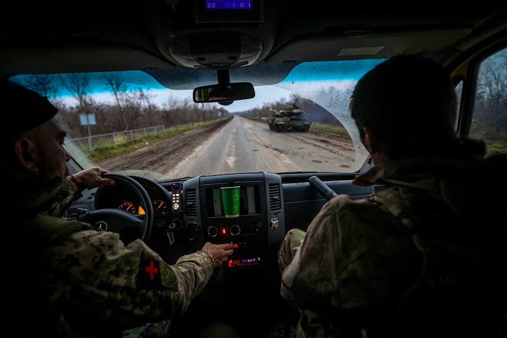 This photograph taken on November 28, 2022, shows volunteer medics from PDMSh (The First Volunteer Mobile Hospital) evacuating a wounded Ukrainian soldier from a stabilizing mobile hospital in the vicinity of Bakhmut, Donetsk region, amid the Russian invasion of Ukraine. - Once known for its vineyards and cavernous salt mines, Bakhmut has now been dubbed 