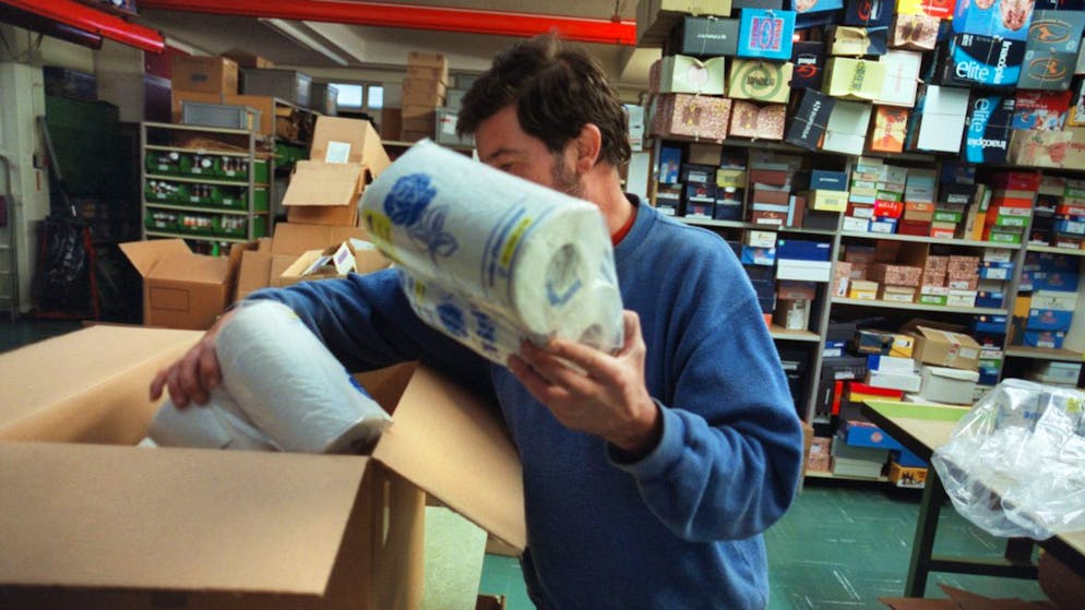 Ein Mann mit Behinderungen verpackt Haushaltspapier in einer Werkstatt für Menschen mit Behinderungen (Archivbild).