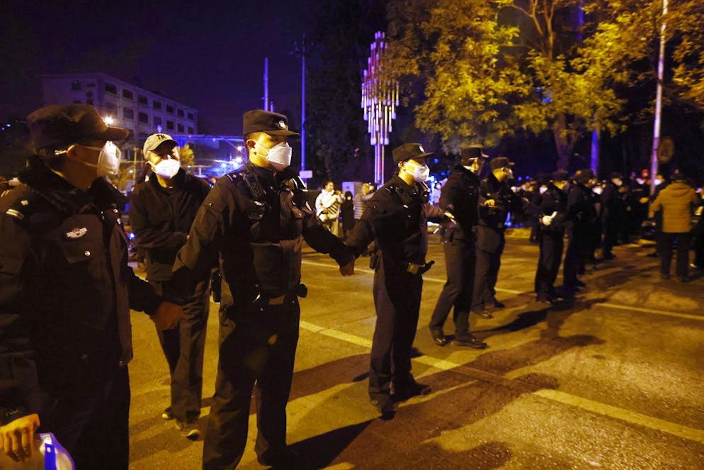 Des policiers chinois formant une barricade lors d'une manifestation déclenchée par un incendie à Urumqi qui a tué 10 personnes à Pékin, en Chine, le 27 novembre 2022.