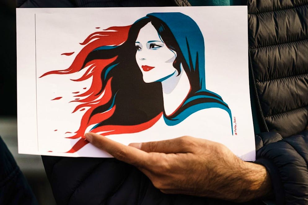 L'Iran è in subbuglio dalla morte di Mahsa Amini, una curda iraniana di 22 anni deceduta il 16 settembre scorso dopo essere stata arrestata dalla polizia per aver violato il codice di abbigliamento della Repubblica islamica, che richiedeva alle donne di indossare il velo (immagine simbolica di un'illustrazione mostrata durante una protesta a Berlino in settembre).