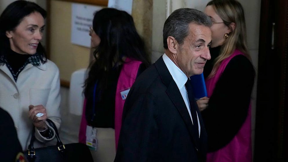 Nicolas Sarkozy (M), ehemaliger Präsident von Frankreich, kommt im Gerichtssaal an, um sich zu verantworten. Sarkozy wurde im März 2021 wegen Bestechung und unerlaubter Einflussnahme zu einer Haftstrafe von drei Jahren verurteilt. Foto: Francois Mori/AP/dpa
