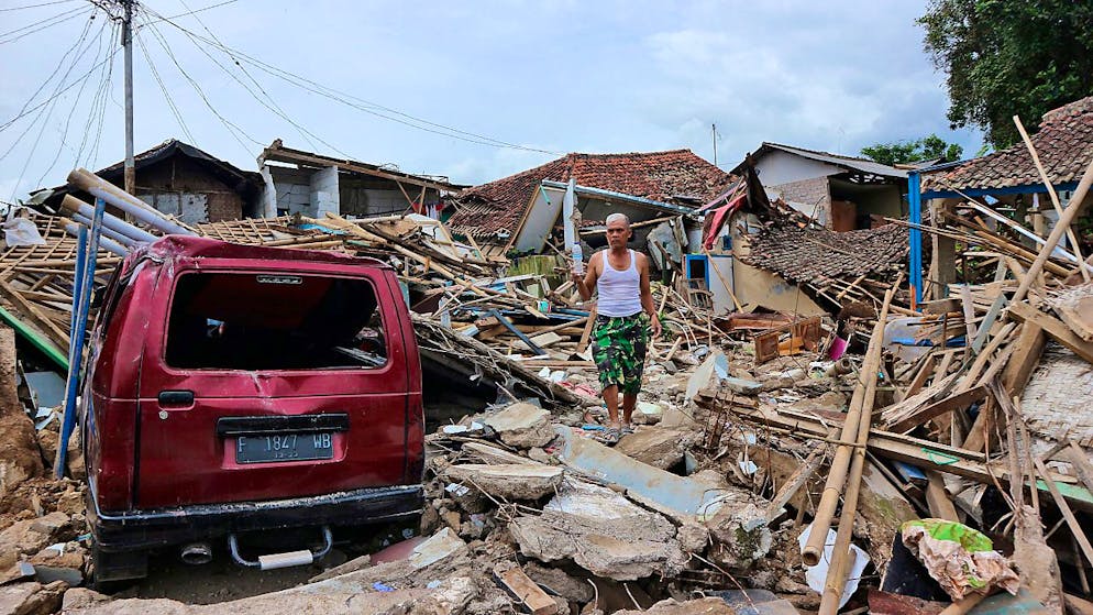 Seorang pria berjalan di atas puing-puing rumah di lingkungan yang rusak parah akibat gempa 21 November 2022. Gempa berkekuatan 5,6 itu menewaskan ratusan orang, termasuk banyak anak, dan melukai ribuan orang.  Foto: Rangga Firmansyah/AP/dpa