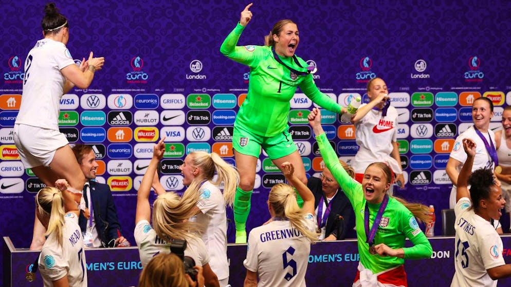 Die Engländerinnen crashen nach dem Triumph bei der Heim-EM 2022 die Pressekonferenz der Trainerin – auf dem Tisch tanzen Torhüterin Mary Earps und Lucy Bronze.