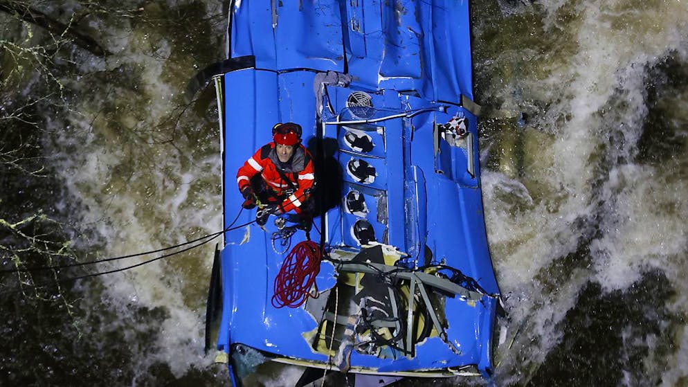 Un pompier porte secours aux passagers d'un bus tombé dans une rivière en Galice.