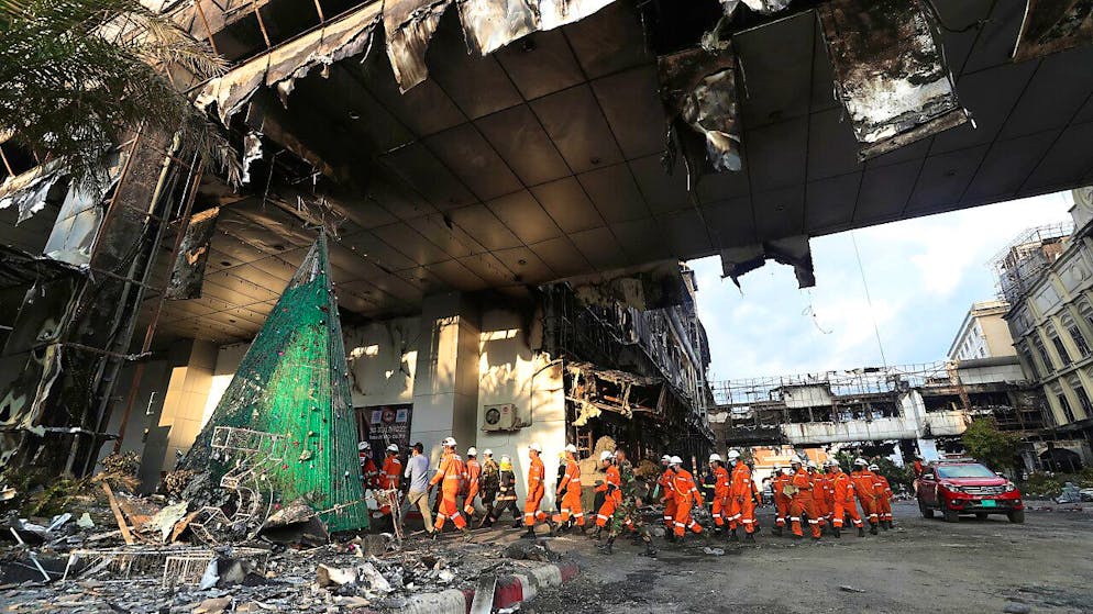 Kambodschanische und thailändische Rettungsexperten führen nach dem Brand in einem kambodschanischen Kasino-Hotel eine Suchaktion durch. Foto: Heng Sinith/AP/dpa