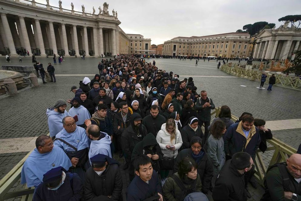 I credenti aspettano in fila la mattina di lunedì 2 gennaio per entrare nella Basilica di San Pietro a Roma, dove il defunto Papa Benedetto XVI è deposto.