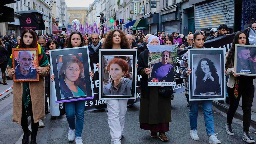 FILED - Menschen halten Poster mit den Gesichtern der bei dem Angriff getöteten Kurden in Paris. Photo: Remon Haazen/ZUMA Press Wire/dpa