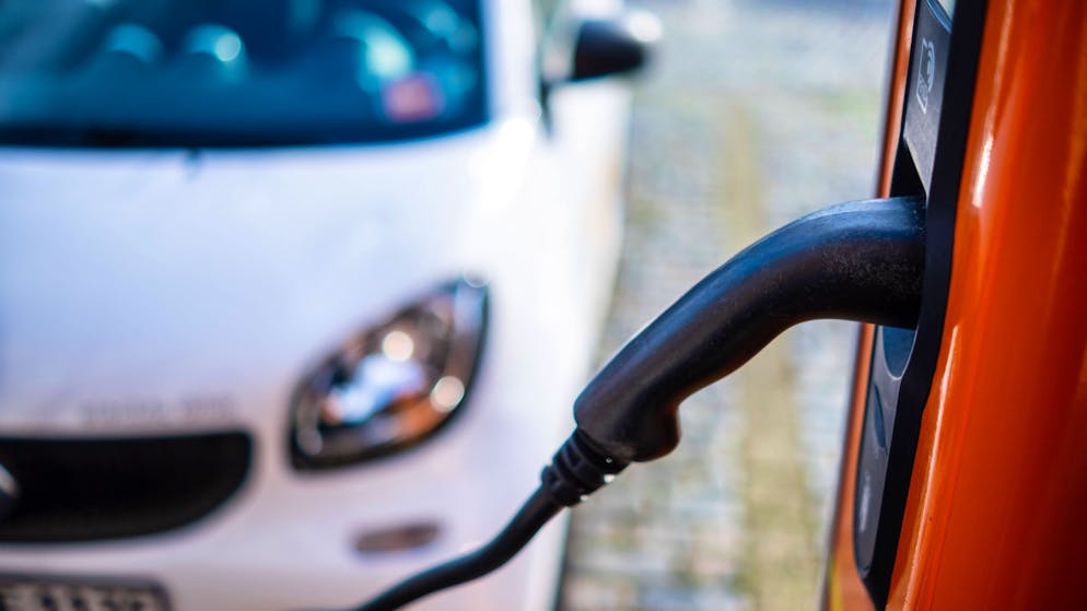 Ein E-Auto lädt an einer öffentlichen Ladestation. Mit der neuen V2G-Technologie können angeschlossene E-Fahrzeuge gespeicherten Strom in Fällen von Engpässen wiedereinspeisen.