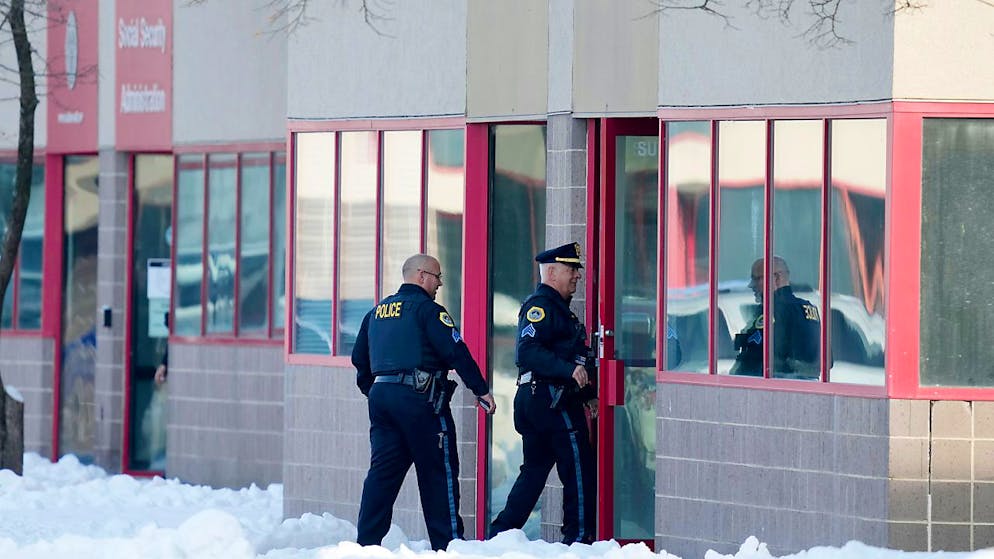Polizisten gehen in Des Moines, Iowa, in das Gebäude von Starts Right Here. Foto: Charlie Neibergall/AP/dpa