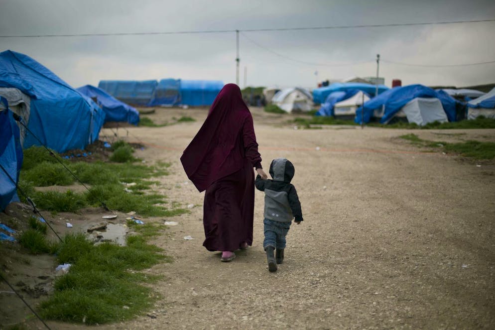 Sur cette photo du 27 mars 2019, Samira, de Belgique, marche avec son fils au Camp Roj, dans le nord de la Syrie. C’est de ce camp de prisonniers jihadistes que viennent les quinze rapatriées françaises et leurs 32 enfants.