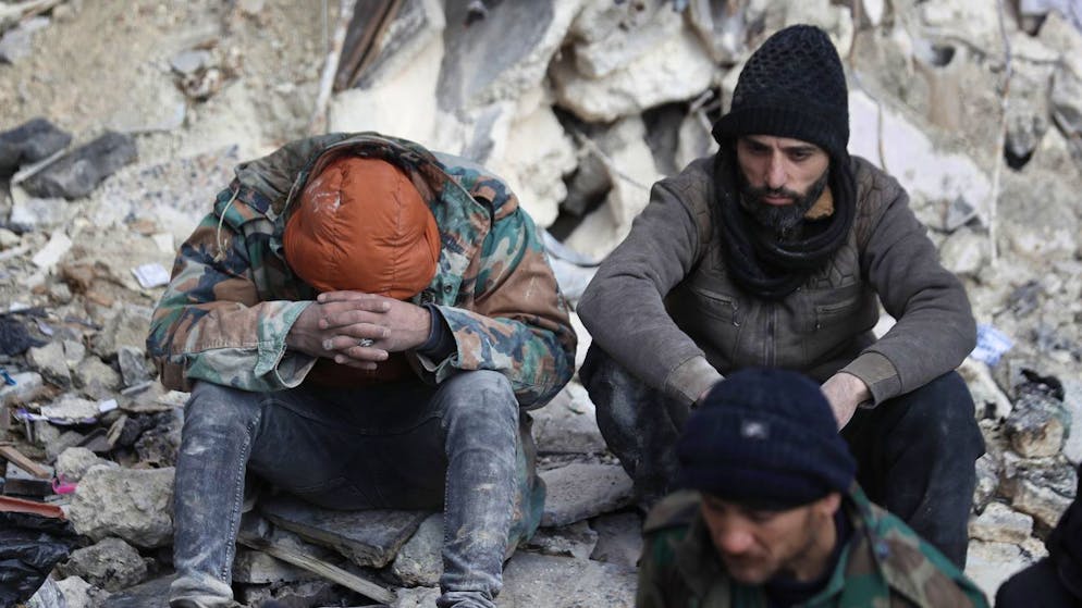 Erdbeben in der Türkei und in Syrien. <strong>7. Februar, Syrien:</strong> Erschöpfte Männer gönnen sich in Aleppo eine Pause, nachdem sie mehrere Menschen lebendig aus den Trümmern bergen konnten.