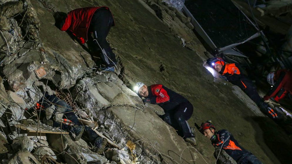 Erdbeben in der Türkei und in Syrien. <strong>6. Februar, Türkei:</strong> Rettungskräfte legen am Montagabend in Hatay ihr Ohr auf Trümmerteile, um verschüttete Überlebende zu hören.