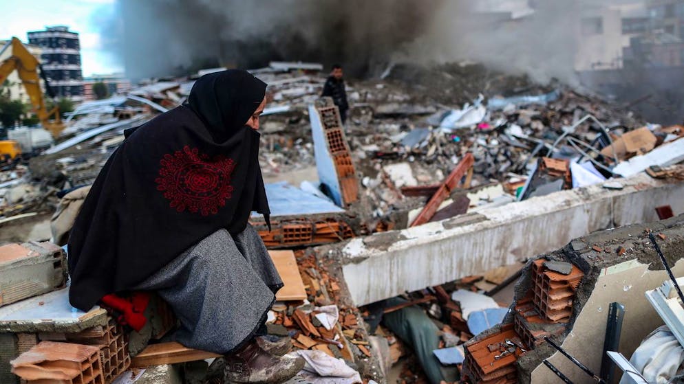 Erdbeben in der Türkei und in Syrien. <strong>7. Februar, Türkei:</strong> Eine Frau sucht in Hatay nach ihrem Hab und Gut.