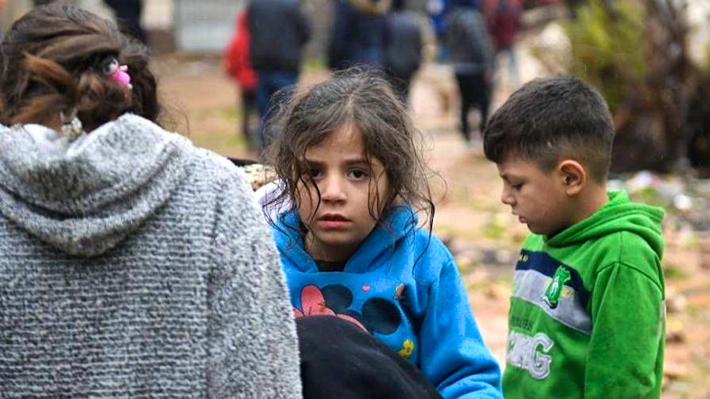 Erdbeben in der Türkei und in Syrien. <strong>7. Februar, Syrien:</strong> Kinder stehen in Aleppo neben einem eingestürzten Haus.