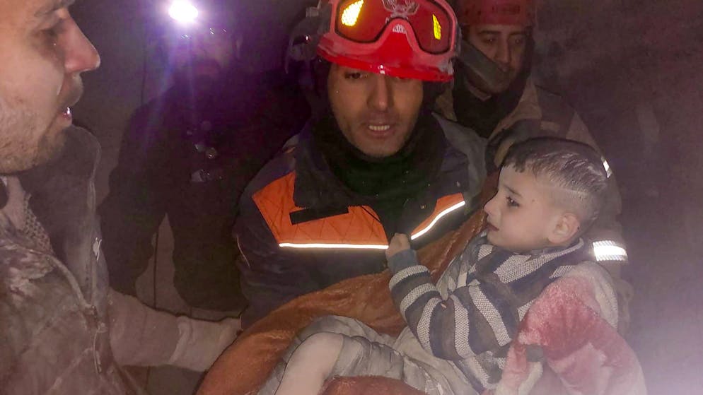 Erdbeben in der Türkei und in Syrien. <strong>8. Februar, Türkei:</strong> Feuerwehrleute aus Istanbul ziehen in der Nacht auf Mittwoch ein Kind aus den Trümmern