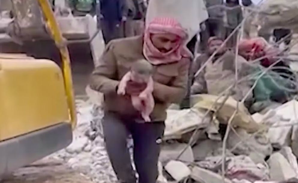 Dschinderis bei Aleppo in Syrien: Retter haben den Säugling unter den Trümmern hervorgezogen.