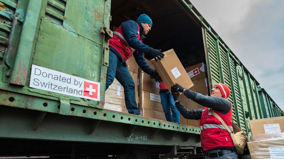Mitglieder des Sofort-Einsatz-Teams (SET) des Schweizerisches Korps für Humanitäre Hilfe (SKH) helfen mit dem Belad eines Zuges mit Schweizer Hilfsgüter, am Sonntag, 6. Maerz 2022, im polnisch-ukrainischen Grenzgebiet im März 2022. 