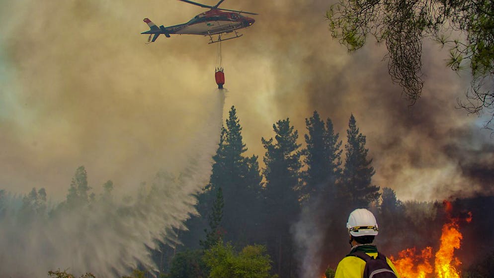 Ein Hubschrauber ist bei den Löscharbeiten während eines Waldbrandes in Chillan im Einsatz. Foto: Jose Humberto Campos/Agencia Uno/dpa