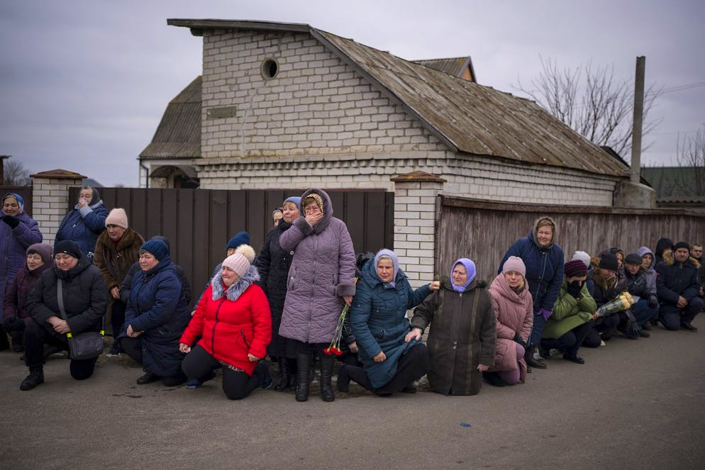 Einwohner*innen knien in Bachmut nieder, während sie auf einen Trauerzug warten. Mitte Februar sind von ursprünglich 70'000 Zivilisten weniger als 5000 in der Stadt. 
