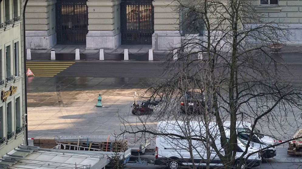Der verdächtige Personenwagen (schwarz, hinter dem Baum) vor dem Bundeshaus wird derzeit mit einem Bombenroboter der Polizei untersucht.