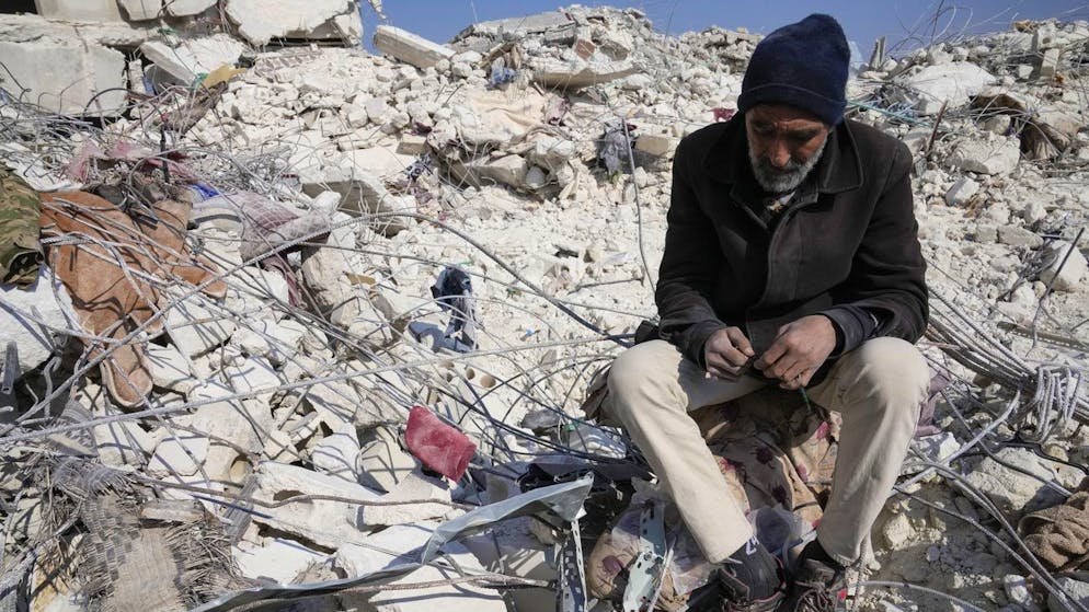 Ein Mann sitzt in den Trümmern eines zerstörten Hauses in Atareb. (12. Februar 2023) 