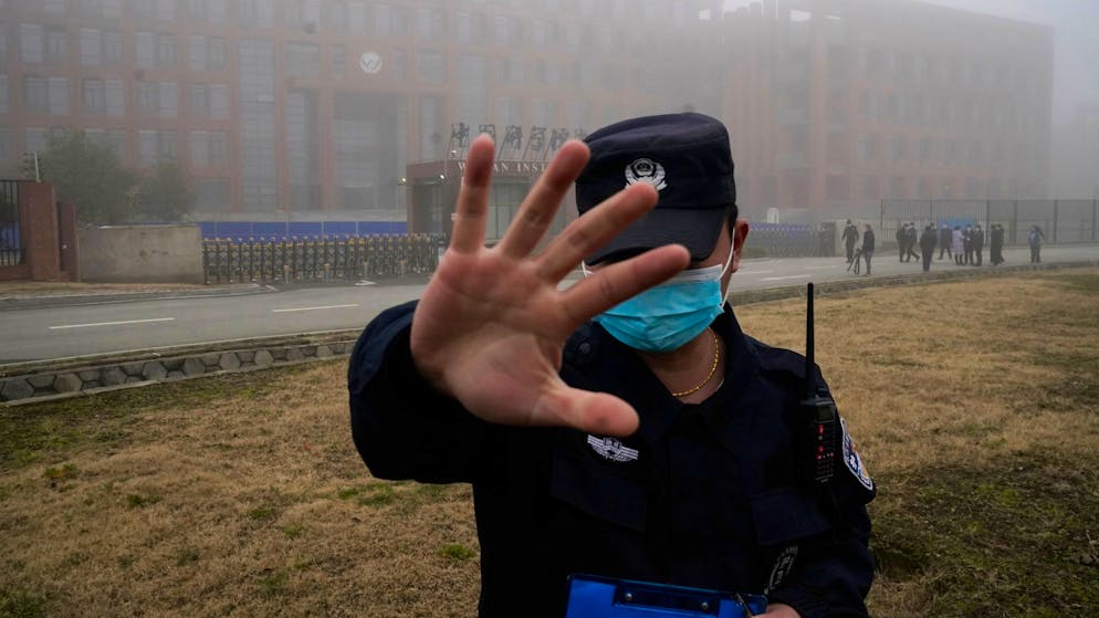 Ein Security-Mitarbeiter versucht im Februar 2021 vor dem Institut für Virologie in Wuhan, Journalisten am Fotografieren zu hindern: China hat die Hypothese stets zurückgewiesen, dass das Coronavirus aus dem Labor entwichen sein könnte.