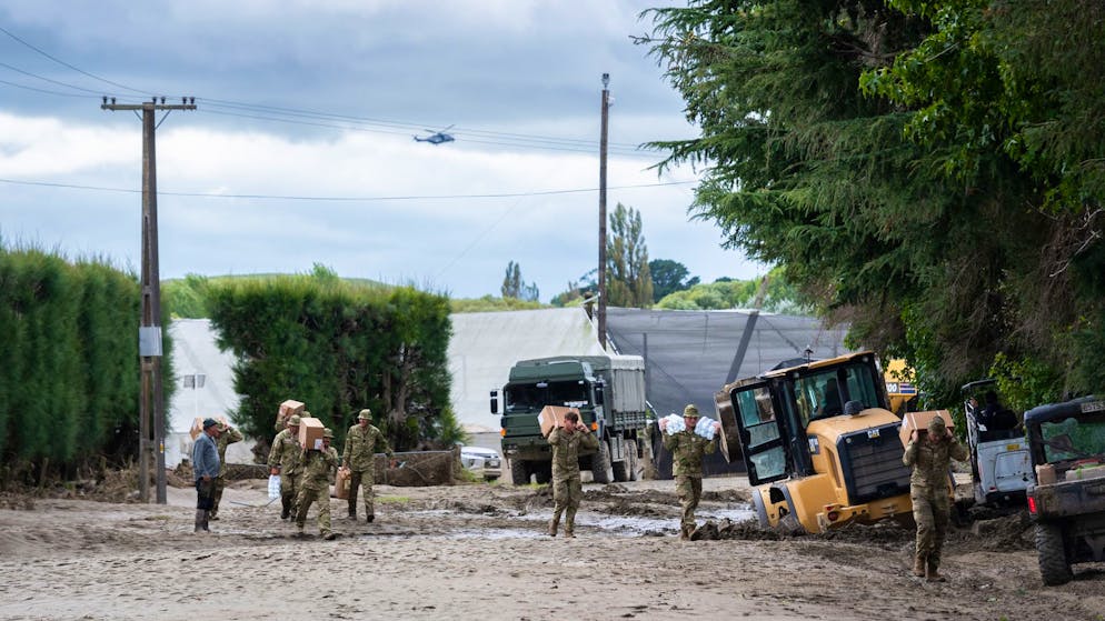 Riesige Schäden in Neuseeland durch Zyklon «Gabrielle» - Gallery. Soldaten der neuseeländischen Streitkräfte bringe Vorräte zum Moteo Marae in der Nähe von Puketapu am Ufer des Tutaekuri-Flusses.