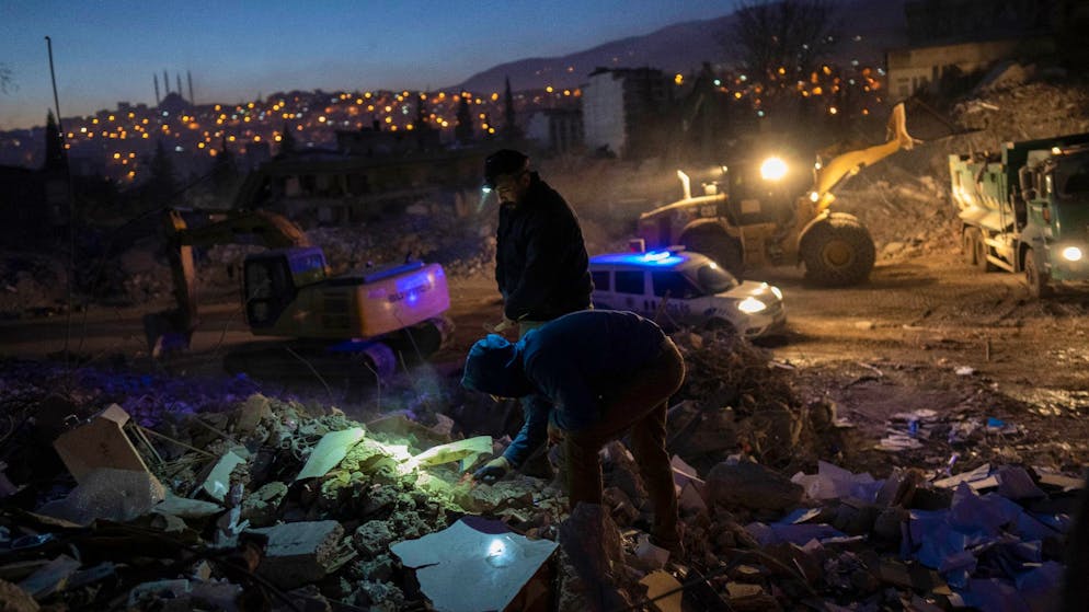 Mehr als 46.000 Tote – viele Schulen in Syrien zerstört - Gallery. Menschen suchen nach persönlichen Gegenständen in den Trümmern eines zerstörten Gebäudes in Kahramanmaras.