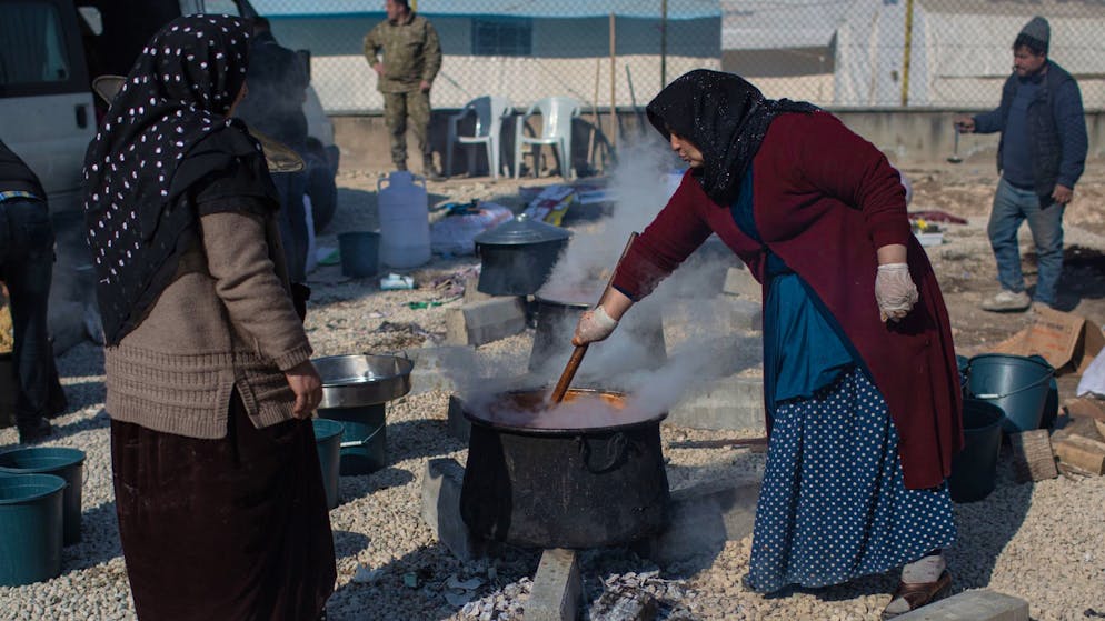 Mehr als 46.000 Tote – viele Schulen in Syrien zerstört - Gallery. Türkische Frauen bereiten in einem Behelfslager in Kahramanmaras draussen Essen zu.