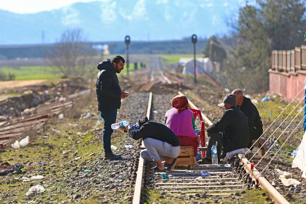 Ein Mann wäscht sich die Haare mit Wasser aus einer Petflasche im Katastrophengebiet in der Türkei. 