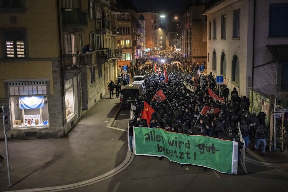 Menschen demonstrieren am 18. Februar 2023 gegen die genossenschaftliche Überbauung auf dem ehemalig besetzten Koch Areal in Zürich. Es kam zu Sachbeschädigung und Verhaftungen. 