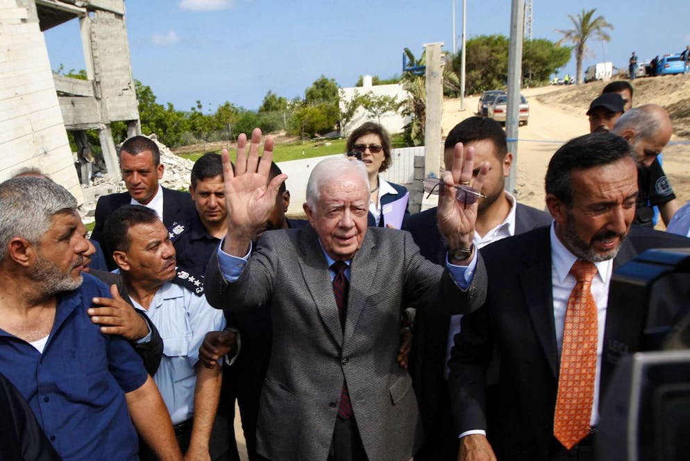 Former US President Jimmy Carter, center, gestures as he speaks to the media at the ruins of the American International School, which was destroyed during Israel's offensive in Gaza earlier this year, in Beit Lahiya, northern Gaza Strip, Tuesday, June 16, 2009.Carter says he's trying to persuade Hamas leaders to accept the international community's conditions for ending its boycott of the Islamic militant group. (AP Photo/Khalil Hamra)