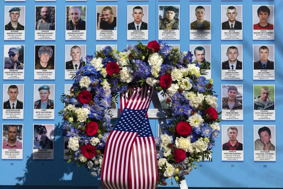 Flowers placed by the President Joe Biden at the Memorial Wall of Fallen Defenders of Ukraine in Russian-Ukrainian War with photos of killed soldiers in Kyiv, Ukraine, Monday, Feb. 20, 2023. (AP Photo/Efrem Lukatsky)