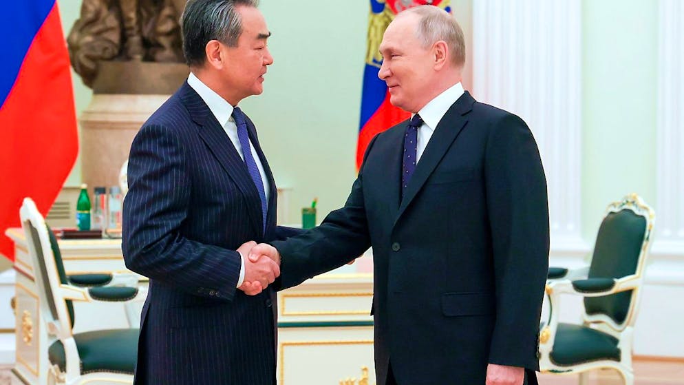 Dieses von der staatlichen russischen Nachrichtenagentur Sputnik via AP veröffentlichte Foto zeigt Wladimir Putin (r), der den chinesischen Außenpolitiker Wang Yi im Kreml begrüßt. Foto: Anton Novoderezhkin/Pool Sputnik Kremlin/AP/dpa - ACHTUNG: Nur zur redaktionellen Verwendung im Zusammenhang mit der aktuellen Berichterstattung und nur mit vollständiger Nennung des vorstehenden Credits