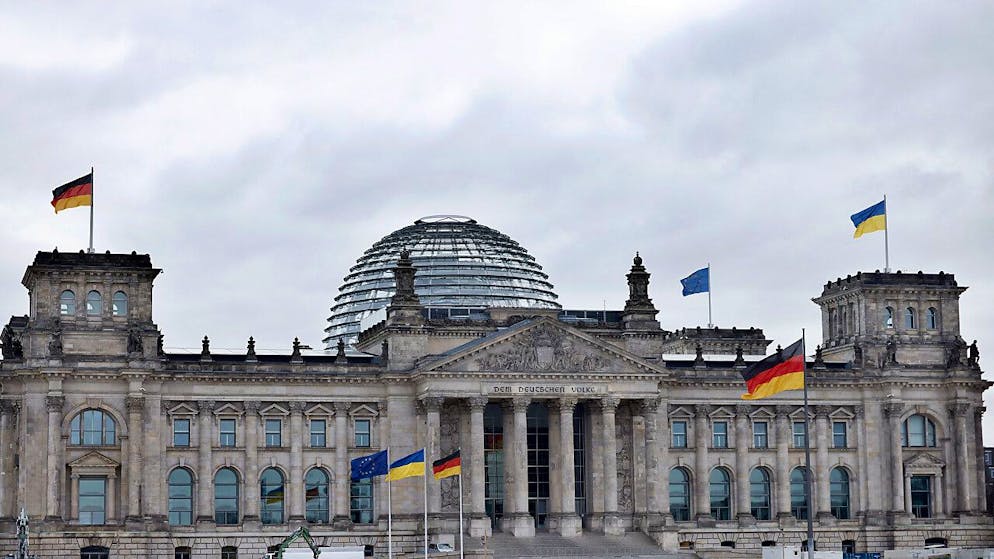Auf dem Reichstagsgebäude ist neben der schwarz-rot-goldene Bundesflagge und Europaflagge die ukrainische Flagge zum Zeichen der Solidarität mit dem ukrainischen Volk gehisst. Foto: Carsten Koall/dpa