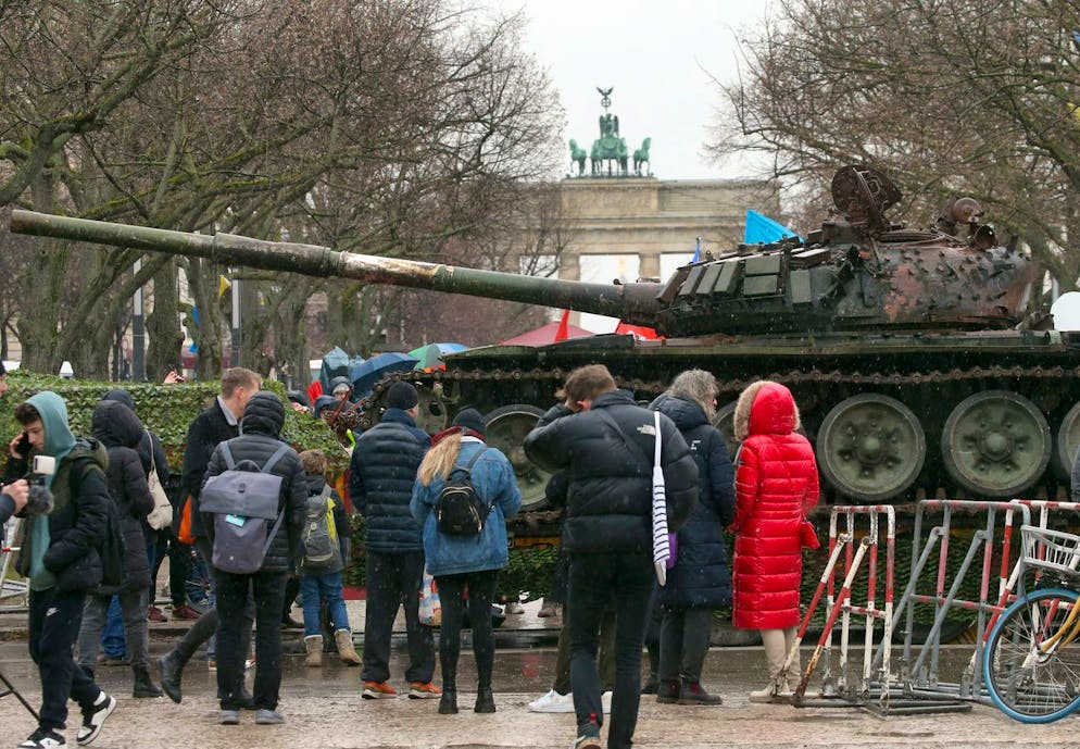 24.02.2023, Berlin: Passanten stehen vor einem in der Ukraine zerstörten russischen Panzer. Der Panzer T-72 steht auf einem Hänger vor der Botschaft Russlands an der Straße Unter den Linden in Berlin. Diese Aktion soll ein Zeichen des Protests gegen den Krieg Russlands sein und soll die Solidarität mit der Ukraine ausdrücken. Die russische Armee hatte die Ukraine am 24.02.2022 überfallen. Im Hintergrund das Brandenburger Tor. Foto: Wolfgang Kumm/dpa +++ dpa-Bildfunk +++ (KEYSTONE/DPA/Wolfgang Kumm)