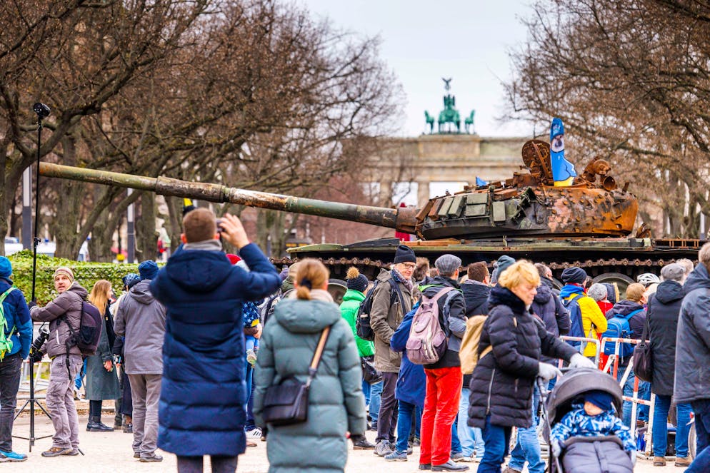 24.02.2023, Berlin: Passanten und Medienvertreter stehen vor einem in der Ukraine zerstörten russischen Panzer. Der Panzer T-72 steht auf einem Hänger vor der Botschaft Russlands an der Straße Unter den Linden in Berlin. Diese Aktion soll ein Zeichen des Protests gegen den Krieg Russlands sein und soll die Solidarität mit der Ukraine ausdrücken. Die russische Armee hatte die Ukraine am 24.02.2022 überfallen. Im Hintergrund das Brandenburger Tor. Foto: Carsten Koall/dpa +++ dpa-Bildfunk +++ (KEYSTONE/DPA/Carsten Koall)