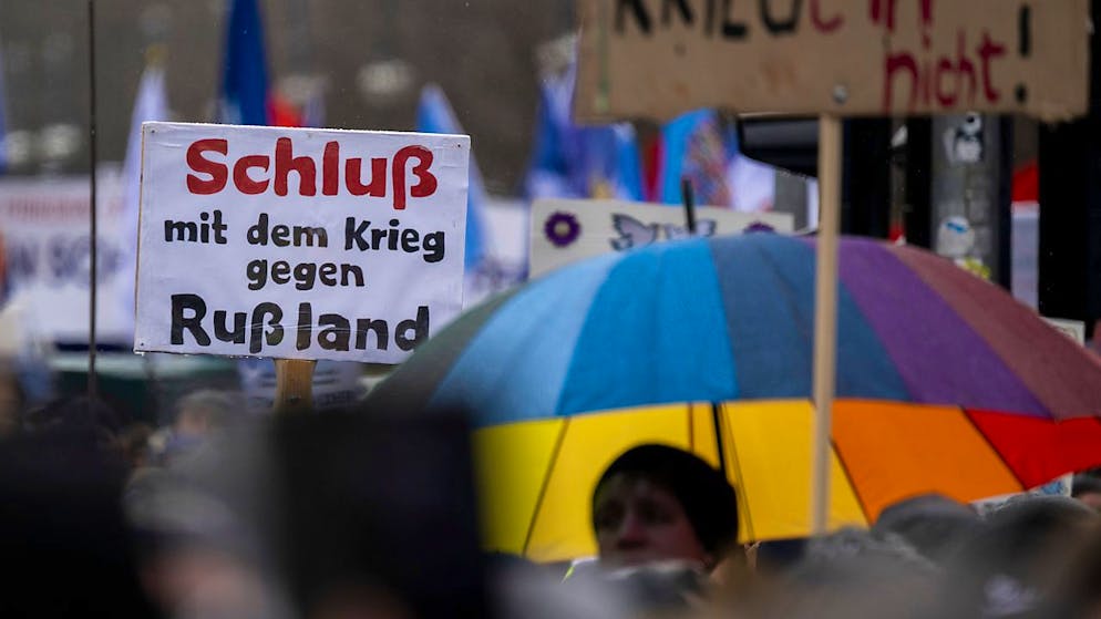 Ein Teilnehmer der Demonstration hält einen Schild mit der Aufschrift «Schluß mit dem Krieg gegen Rußland» hoch. Am Brandenburger Tor in Berlin haben sich mehrere Tausend Menschen zu einer Kundgebung für Verhandlungen mit Russland im Ukraine-Krieg versammelt. Foto: Monika Skolimowska/dpa