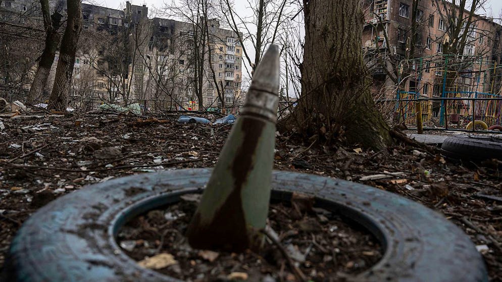 Ein Teil einer Rakete ragt aus dem Boden vor einem Wohnhaus im ukrainischen Wuhledar, das von den russischen Streitkräften schwer bombardiert wurde. Foto: Evgeniy Maloletka/AP/dpa
