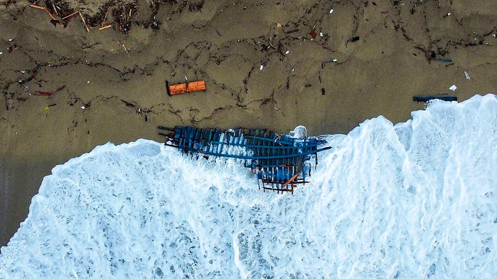 Blick auf einen Teil des Wracks eines gekenterten Bootes, das an einem Strand angeschwemmt wurde. Foto: Luigi Navarra/AP/dpa