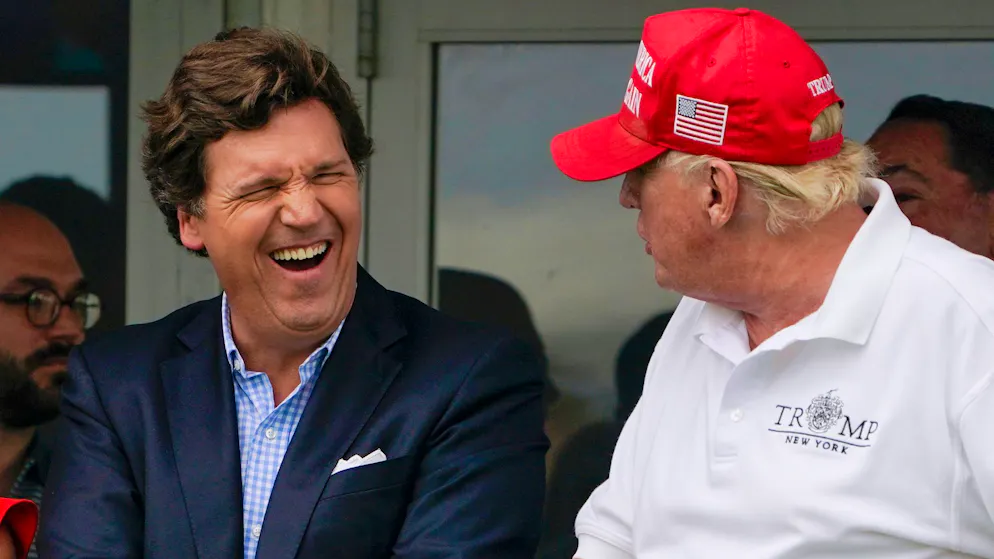 Fox-News-Moderator Tucker Carlson scherzt mit Ex-Präsident Donald Trump. Der konservative Fernsehsender ebnete Trumps Politikstil den Weg.