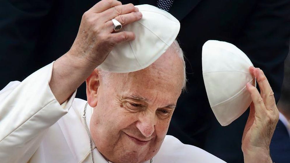 Papst Franziskus hält während seiner Mittwochs-Generalaudienz auf dem Petersplatz zwei Scheitelkäppchen (Pileolus) in den Händen.