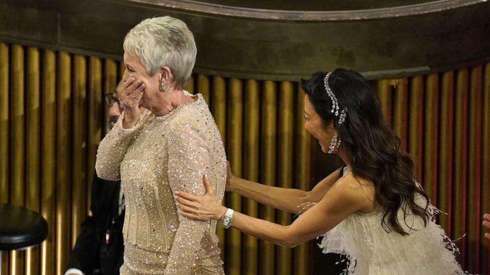 Michelle Yeoh, right, reacts with excitement as Jamie Lee Curtis accepts the award for best performance by an actress in a supporting role for 