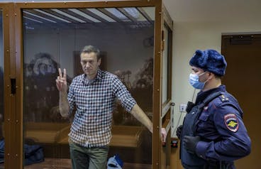 epa09025237 Russian opposition leader Alexei Navalny gestures inside a glass cage prior to a hearing at the Babushkinsky District Court in Moscow, Russia, 20 February 2021. The Moscow City court will hold a visiting session at the Babushkinsky District Court Building to consider Navalny's lawyers appeal against a court verdict issued on 02 February 2021, to replace the suspended sentence issued to Navalny in the Yves Rocher embezzlement case with an actual term in a penal colony. EPA/YURI KOCHETKOV MANDATORY CREDIT