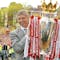 Arsenal manager Arsene Wenger holds up the English Premiership Trophy to thousands of jubilant fans outside Islington Town Hall in North London, Sunday May 16, 2004, during their victory parade. (AP Photo/Lawrence Lustig, Pool)