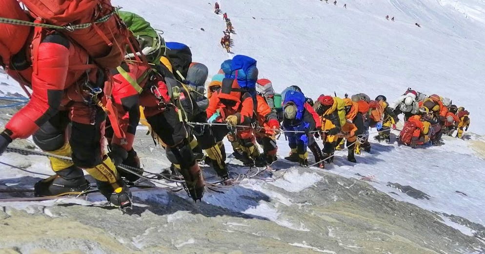 In questa foto del 22 maggio 2019, una lunga coda di alpinisti si snoda lungo un sentiero sul Monte Everest, appena sotto il campo quattro, in Nepal. Gli alpinisti esperti all'epoca affermarono che l'incapacità del governo nepalese di limitare il numero di scalatori sul Monte Everest provocò un pericoloso sovraffollamento e un maggior numero di morti.