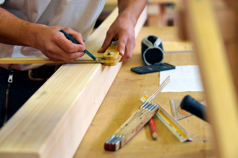 Nella foto le mani di un giovane apprendista falegname impegnate a disegnare.    ©Ti-Press/Gabriele Putzu